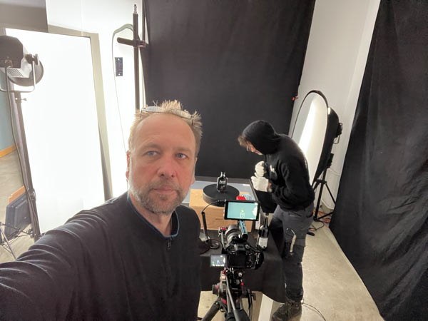 Start 11 Kameramann und DOP Udo Schloermann von der Videoproduktion 52Gradfilm aus Hannover dreht im Studio das Produkt AWAKA Kaffelikör auf dem Drehteller. Im Hintergrund richtet Papa Awaka das produkt noch genau auf em Drehteller aus.